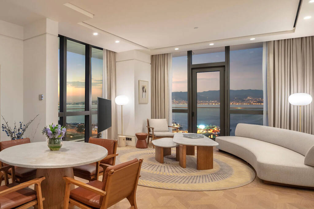 Hyatt Regency Izmir İstinyePark otelinin lüks bir süitinin oturma odası ve İzmir Körfezi manzarası.