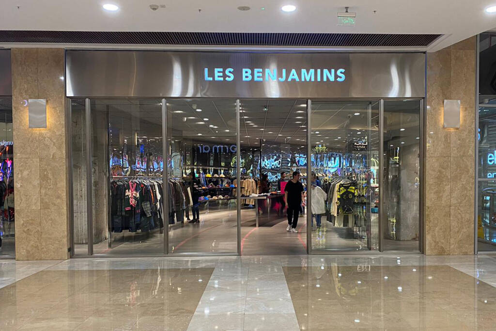 Les Benjamins Kentpark AVM mağazasının giriş kapısı ve iç görünümü, cam kapılar ardında sergilenen giysiler ve alışveriş yapan müşteriler.