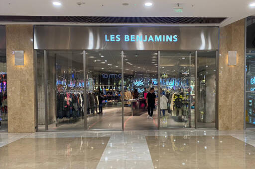 Les Benjamins Kentpark AVM mağazasının giriş kapısı ve iç görünümü, cam kapılar ardında sergilenen giysiler ve alışveriş yapan müşteriler.