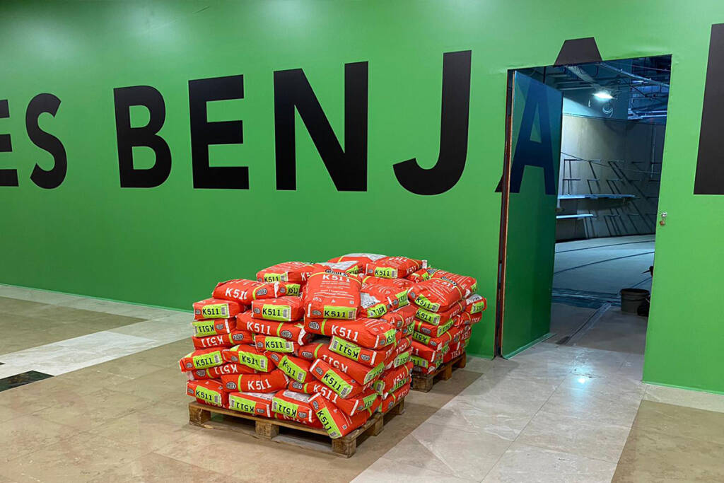 Les Benjamins Kentpark AVM mağazası tadilatı sırasında kullanılan Ardex K511 mikrobeton çuvalları, yeşil mağaza duvarının önünde dizili.