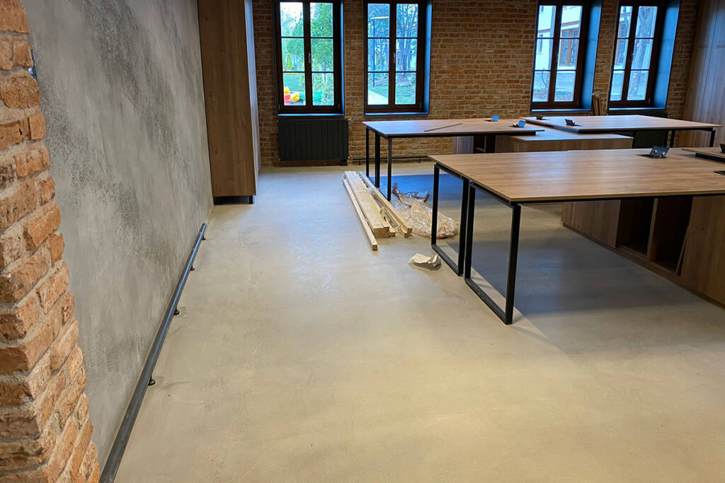 Ofis iç mekanında yeni döşenmiş ARDEX zemin ve ahşap mobilyalar.