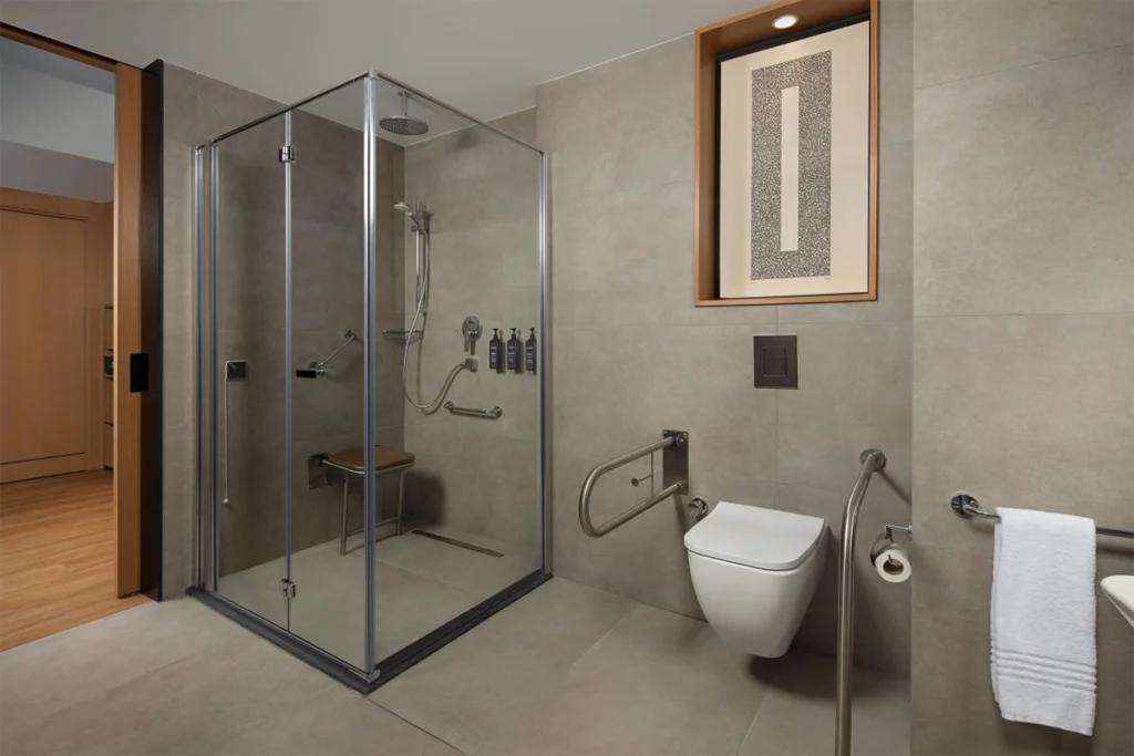Sheraton İstanbul Esenyurt'taki engelli dostu banyo, geniş duş alanı ve destek barlarıyla.