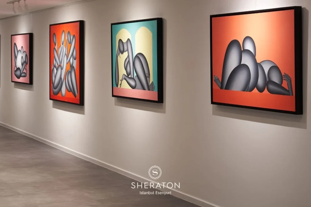 Sheraton İstanbul Esenyurt'taki sanat galerisi, modern sanat eserleriyle dolu aydınlık bir koridor.