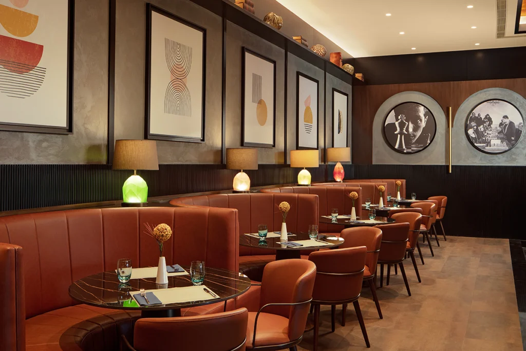 Sheraton İstanbul Esenyurt'taki şık restoran, duvarlarda modern sanat eserleri ve zarif masa düzenlemeleriyle.