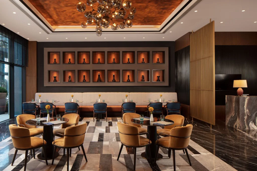 Sheraton İstanbul Esenyurt'taki modern restoran dekoru, zarif aydınlatma ve şık masa düzenlemeleriyle.