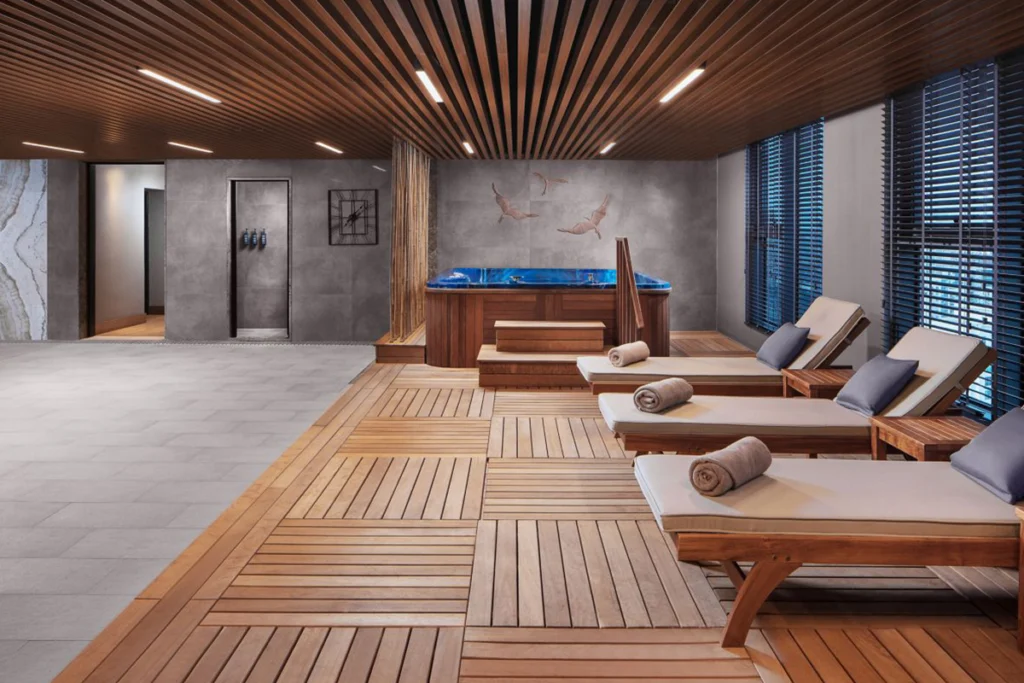 Sheraton İstanbul Esenyurt'taki spa alanı, rahatlatıcı şezlonglar ve şık ahşap zeminlerle.