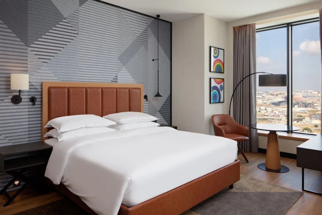 Sheraton İstanbul Esenyurt'taki modern ve şık tasarımlı otel odası, geniş yatak ve şehir manzarasıyla.