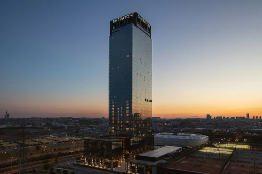 Akşam saatlerinde Sheraton İstanbul Esenyurt'un dış cephe görüntüsü, yüksek kule ve şehir manzarasıyla.